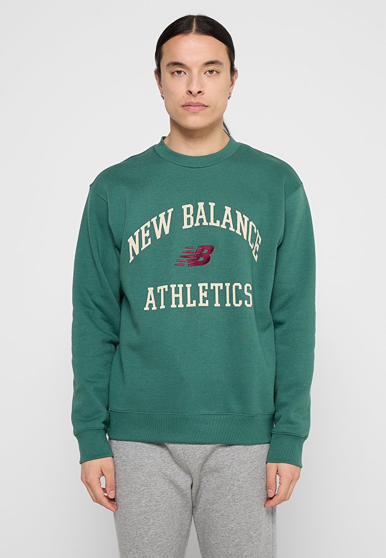 Felpa verde in cotone con la scritta "NEW BALANCE ATHLETICS" in crema e bordeaux, dotata di polsini e orlo a costine per una maggiore struttura.