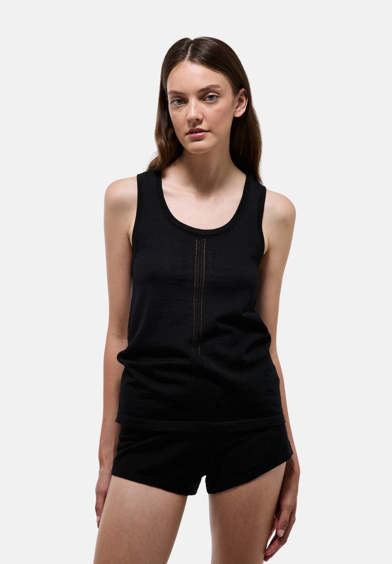 Débardeur noir sans manches en matériau doux, avec une couture verticale texturée au centre, associé à un short noir.