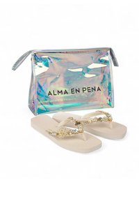 Beige slippers met decoratieve gouden schelpen en parelversieringen, gecombineerd met een transparante iriserende ritszak met zwarte tekst.