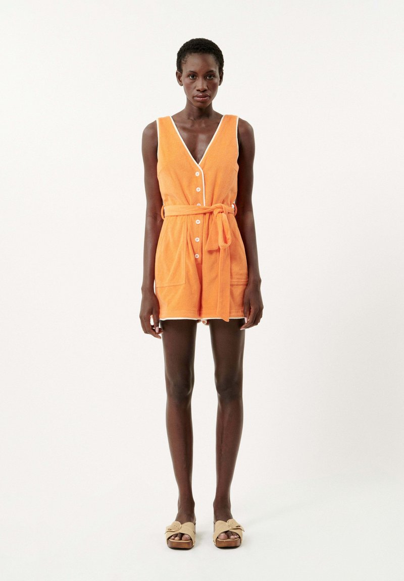 Robe en éponge orange avec un décolleté en V, des boutons devant et une taille ceinturée. Présente des finitions blanches et des poches latérales ; longueur courte.