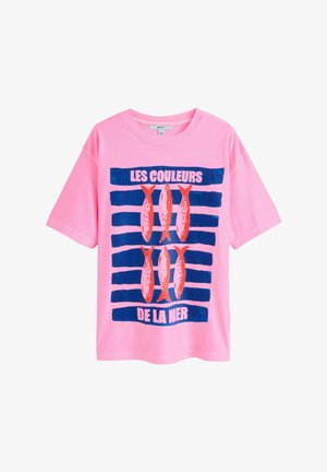Pink short-sleeve t-shirt featuring a blue striped design with red and orange fish graphics, and the text "LES COULEURS DE LA MER."