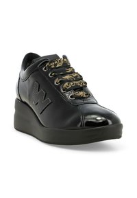 Sneaker nera in pelle con finitura lucida, dotata di lacci con motivo dorato, suola a cuneo e un distintivo logo "W" sul lato.