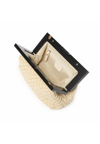 Bolso rectangular con un exterior de color beige tejido y tapa negra lisa. El interior cuenta con un forro crema y un bolsillo con cremallera.