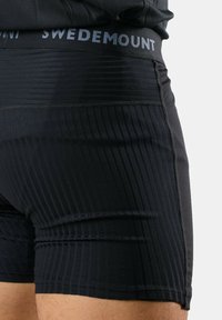 Black athletic shorts with a textured ribbed design and a contrasting gray waistband labeled "SWEDEMOUNT." Smooth fabric with stretch.