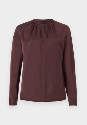 Μπλούζα μακριά μανίκια, σκούρου καφέ χρώματος, με σούρα στον λαιμό και κρυφά κουμπιά μπροστά, κατασκευασμένη από λείο ύφασμα.