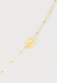 Λεπτό χρυσό βραχιόλι αλυσίδας με μικρές χάντρες και οβάλ θρησκευτικό μενταγιόν περιτριγυρισμένο από διαυγή κρύσταλλα.