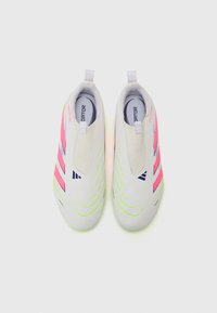 Zapatos de fútbol con una parte superior gris lisa, que presentan rayas rosas y azules. Diseño sin cordones con detalles verdes a lo largo de la suela.