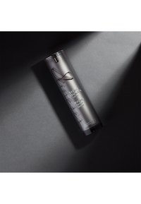 Schwarze zylindrische Flasche mit mattem Finish, erhabenem Text und silbernen Akzenten. Enthält ein Hautpflegeprodukt. Einfaches Design, keine Muster.