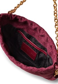 Borsa in tessuto bordeaux con esterno testurizzato, tracolla in catena dorata e interno nero a motivo con etichetta e slot per carta.