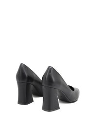 Scarpe con tacco alto in pelle nera, con punta arrotondata e tacco spesso, caratterizzate da una superficie liscia e un design minimalista.