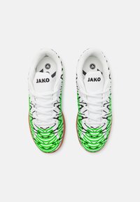 Białe sportowe buty z zielono-czarnym wzorem, z teksturowanym fasonem, okrągłym noskiem i sznurowanym przodem. Metka z napisem "JAKO."