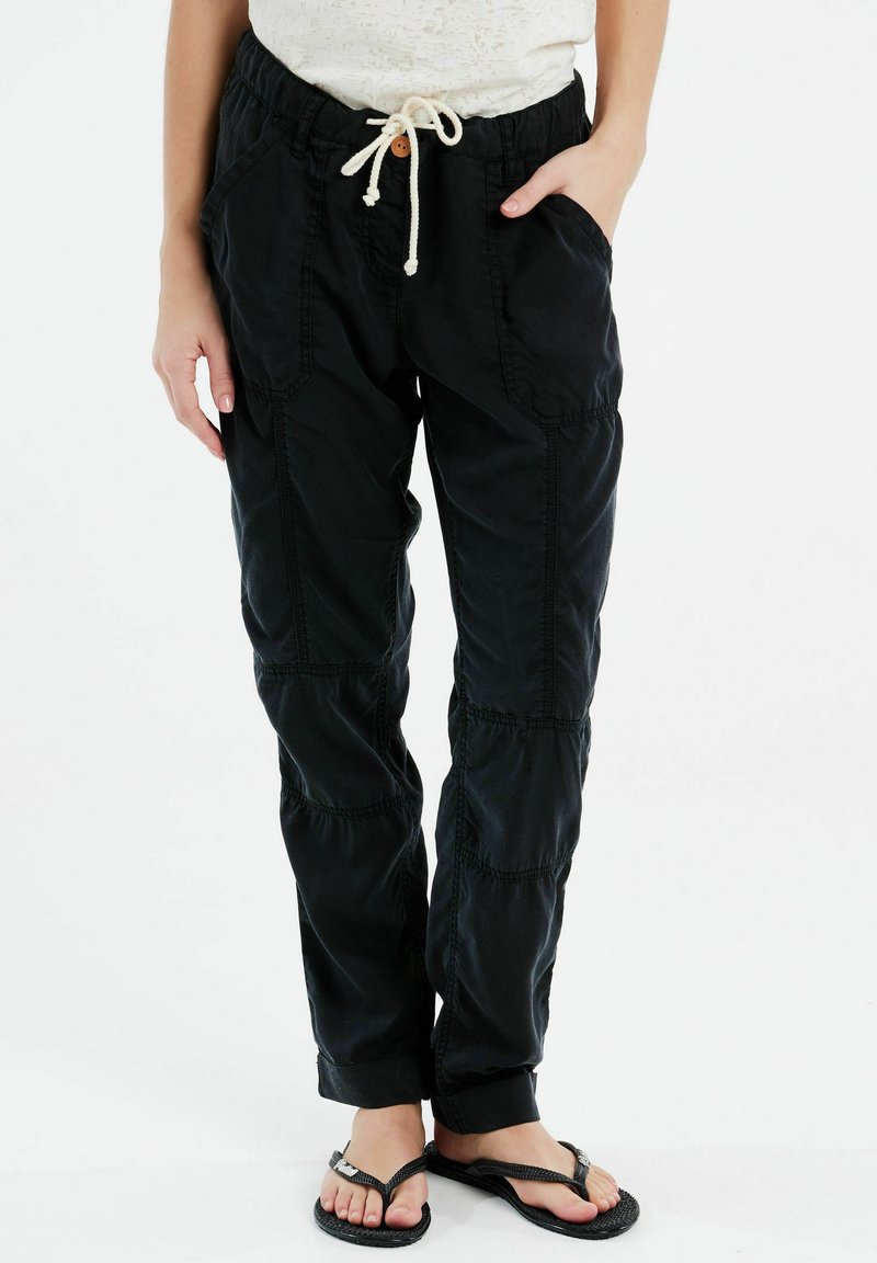 Zwarte cargobroek heeft een relaxed fit, elastische tailleband met trekkoord, zijzakken en contrasterende stikseldetails.