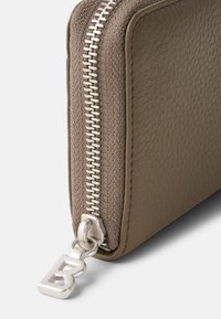 Brown textured leather wallet with a silver metal zipper. Features a logo charm on the zipper pull, showcasing a clean, rectangular design.