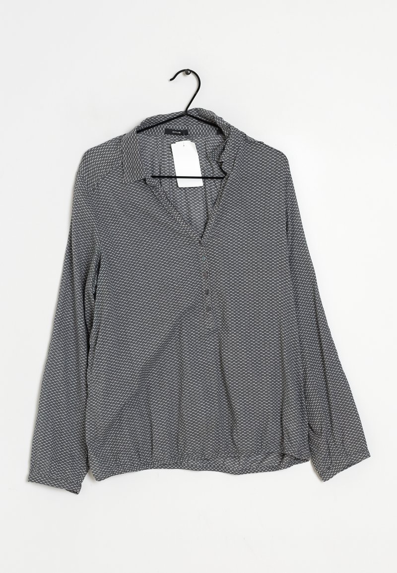 Long-sleeve blouse in a gray fabric with a subtle geometric pattern, featuring a collar and button placket, hanging on a black hook.