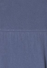 Rękaw w głębokim niebieskim kolorze, ukazujący teksturowany wzór z poziomymi liniami na materiale. Brak widocznych akcentów lub elementów metalowych.