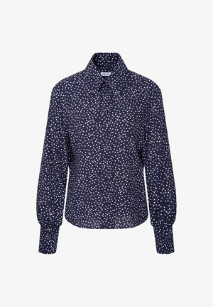 Marineblå langærmet bluse med hvide uregelmæssige prikker, knaplukning foran og bred krave med knapdetaljer.