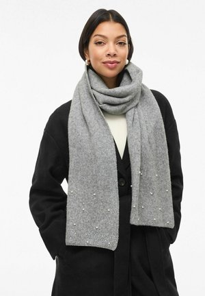 Grå ullskjerf med myk tekstur, dekorert med perleaktige detaljer og elegant fall, båret over en svart jakke.