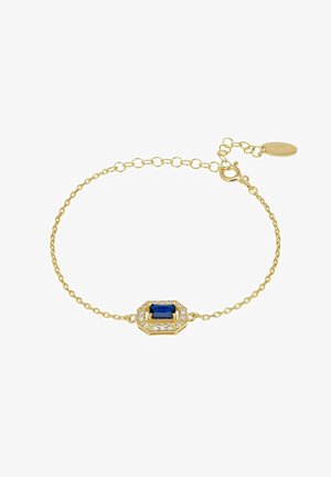 Bracelet délicat en chaîne d'or avec une pierre précieuse rectangulaire bleue au centre, entourée de petits cristaux clairs, équipé d'un fermoir réglable avec une étiquette.