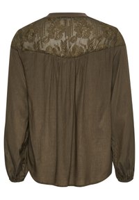 Blouse vert olive avec un dos en dentelle florale, coupe décontractée, manches longues avec des poignets élastiques et texture subtile sur l'ensemble du tissu.