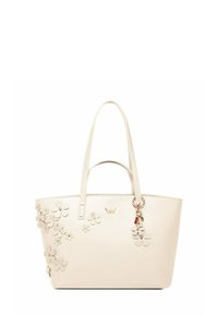 Krémová taška přes rameno s květinovými aplikacemi na straně, dvojitými rukojetmi a přívěskem. Vyrobena z hladkého materiálu se strukturovaným obdélníkovým tvarem.
