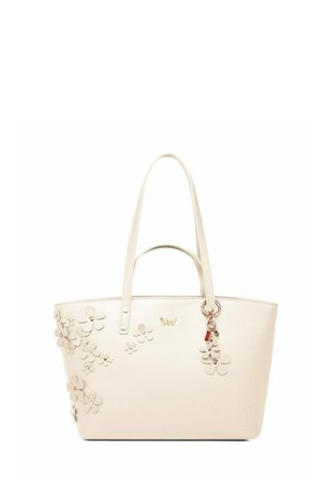 Krémová taška přes rameno s květinovými aplikacemi na straně, dvojitými rukojetmi a přívěskem. Vyrobena z hladkého materiálu se strukturovaným obdélníkovým tvarem.