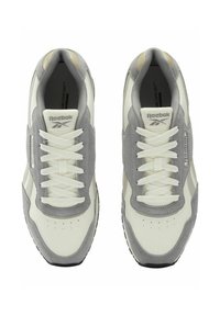 Zapatillas deportivas en blanco y gris con acabado en cuero liso y gamuza, que cuentan con cordones redondos, detalles perforados y una suela negra.