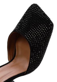Scarpa nera open-toe con punta quadrata e una superficie morbida e testurizzata decorata con piccoli e lucidi rivetti neri. Soletta in pelle morbida visibile.