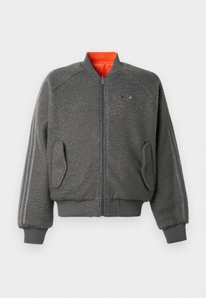 Sivi teksturirani bomber jakna sa zatvaračem, ribanim manžetama i donjim rubom, preklopnim džepovima, suptilnim Adidas logotipom i narančastim oblogom ovratnika.
