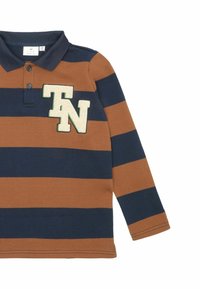Polo tričko s dlouhými rukávy v tmavě námořnické modré a hnědé barvě s vodorovnými pruhy. Má límec a vyšívané logo "TN" v krémové a zelené barvě na hrudi.