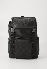 Black backpack featuring a textured front pocket, adjustable straps, and logo hardware. Made of durable material with a sleek design.