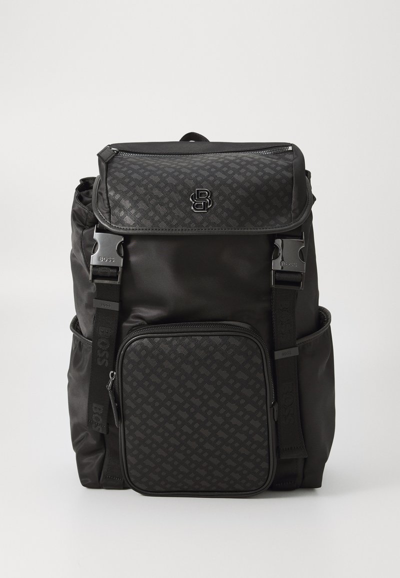 Black backpack featuring a textured front pocket, adjustable straps, and logo hardware. Made of durable material with a sleek design.