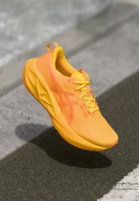Chaussure de sport jaune vif au design élégant, tige en tissu texturé, lacets bien visibles et semelle courbée pour une mobilité améliorée.