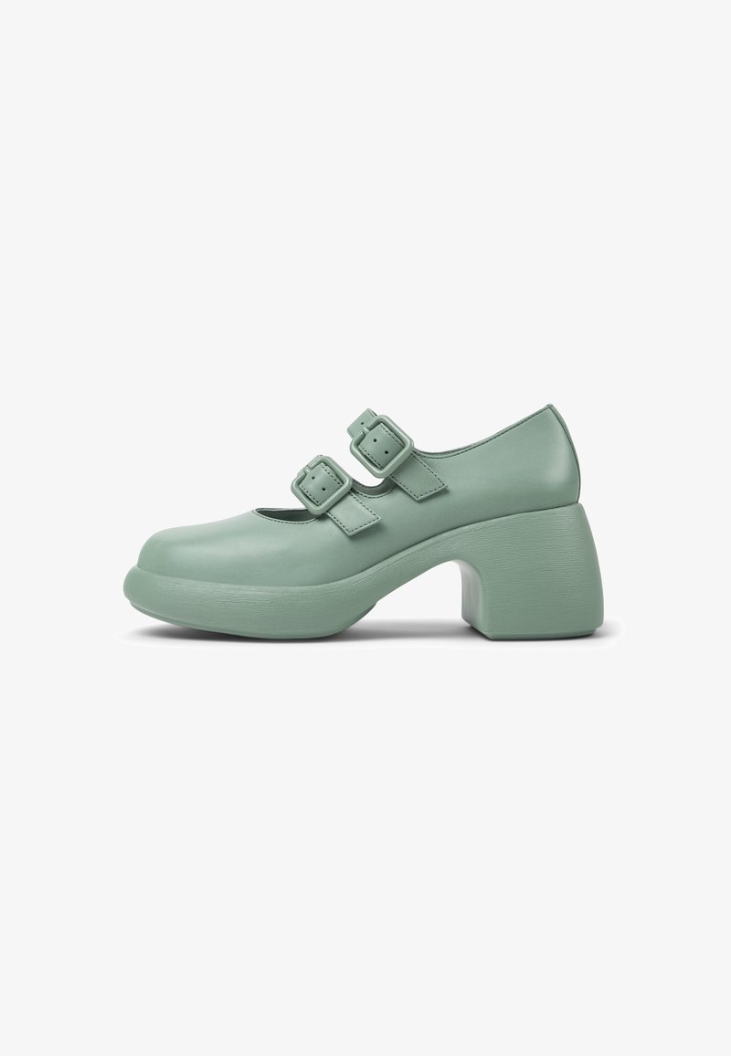 Green leather shoes with a rounded toe, two adjustable buckle straps, and a chunky block heel, featuring a smooth texture and minimalist design.