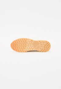 Shoe sole with a hexagonal pattern, light orange color, textured surface, and medium tread depth for grip. Minimal logo detail present.