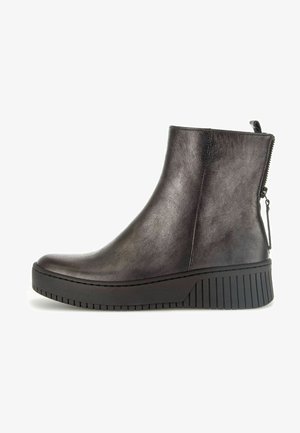 Bottines noires avec une finition en cuir lisse, une fermeture éclair sur le côté et une semelle en caoutchouc épaisse et crantée pour plus de hauteur et de stabilité.