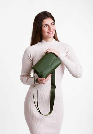 Zelená kožená kabelka přes rameno se strukturovaným designem, nastavitelným popruhem, minimalistickým prošíváním a jemným embosovaným logem.