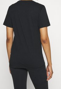 Sort bomulds T-shirt med korte ærmer, en rund halsudskæring og en let afslappet pasform. Bagpå er der en glat, udekoreret overflade.