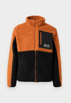Fleece jacket with orange and black color blocking, full zip, high collar, and a black chest pocket with zipper and logo detail.