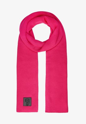 Écharpe tricotée rose vif avec une texture côtelée, bouclée en haut, ornée d'un petit patch noir représentant une personne stylisée portant des lunettes et une cravate.