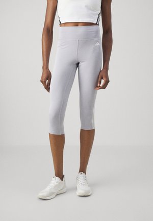 Világosszürke capri leggings, rugalmas anyagból, magas derékkal és diszkrét, háromcsíkos mintával az oldalán.