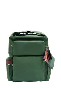 Zielony plecak z nylonu z regulowanymi paskami, wieloma kieszeniami zapinanymi na zamek i akcesorium w postaci kwiatowego breloczka. Gładka tekstura i zorganizowany design.