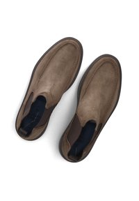 Bruine suède instappers met elastische zijpanelen en een ronde neus. Textuur bovenkant en een contrasterende donkere rubberen zool.