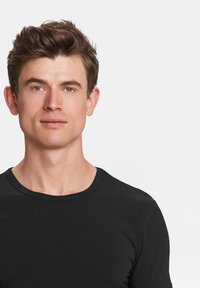 Zwarte korte mouwen t-shirt met een ronde hals, gladde textuur, aansluitend ontwerp, gedragen door een persoon met een lichte huid en kort haar.