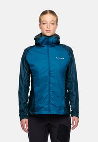 Veste imperméable teal avec capuche, fermeture éclair sur le devant et poignets élastiques. Texture lisse et poches latérales, avec un logo visible sur la poitrine.