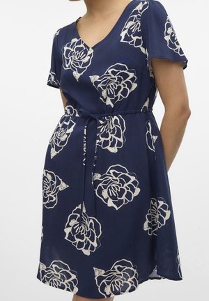 Vestido floral azul marino con escote en V y mangas cortas, que presenta patrones de rosas blancas, un lazo en la cintura y una silueta fluida.