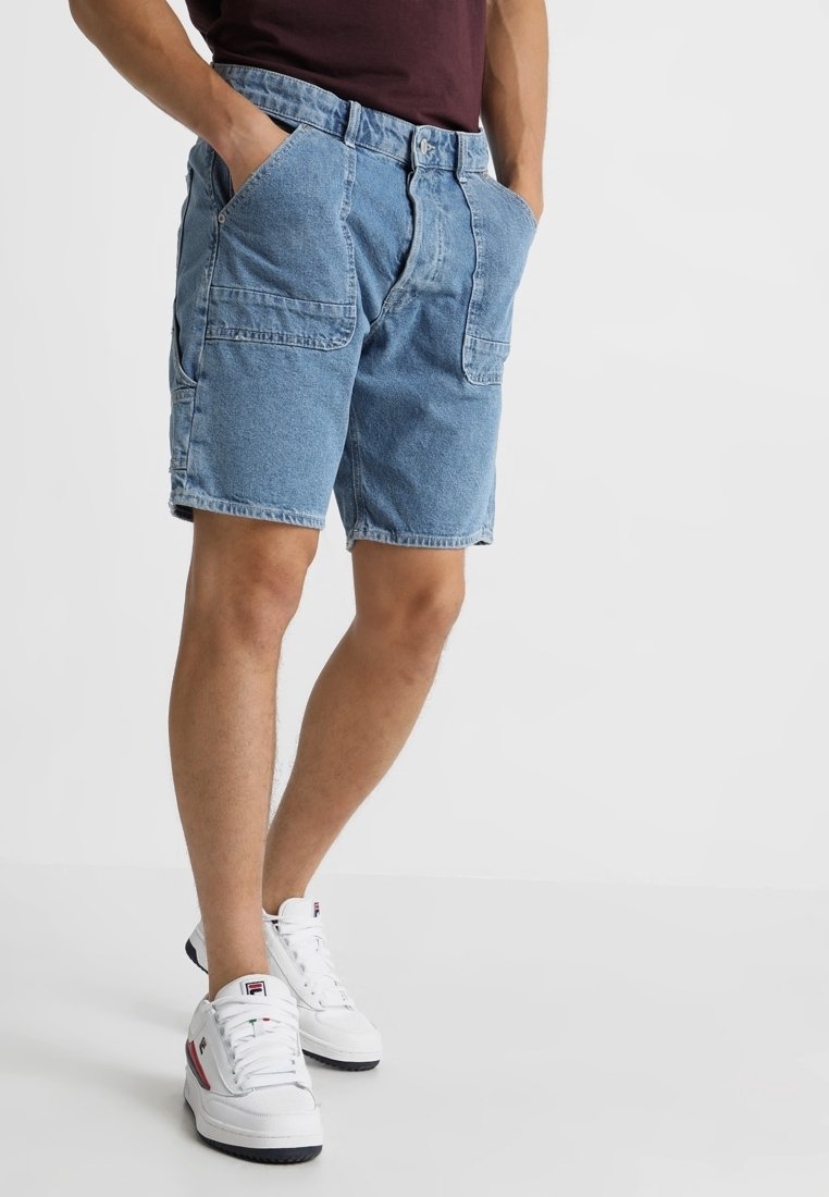Denimshorts i ljusblått, med två framfickor och en lös passform. Matchas med vita sneakers med röda och marinblå detaljer.