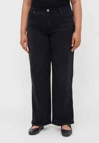 Black wide-leg jeans with a high waist, featuring five pockets, a front button closure, and slight fading for texture.