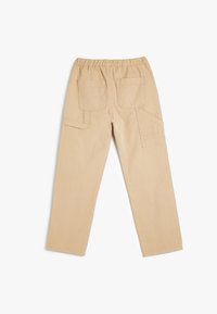 Beige cargohousut, joissa on joustava vyötärö, kaksi takataskua ja sivupockettien k cargo. Kangas näyttää kestävältä ja siinä on sileä pinta.