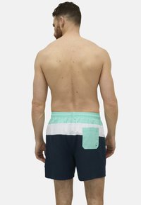 Bañadores de hombre con un diseño en bloques de colores que combina paneles en azul marino, blanco y verde menta. Incluye un bolsillo trasero con una solapa a contraste.