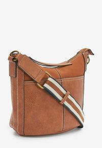 Braune Lederhandtasche mit strukturiertem Finish, ausgestattet mit Kontrastnähten und einem gestreiften Stoff-Schulterriemen mit goldenen Beschlägen.